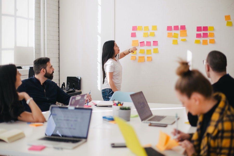 team working together in conference room on an agile board